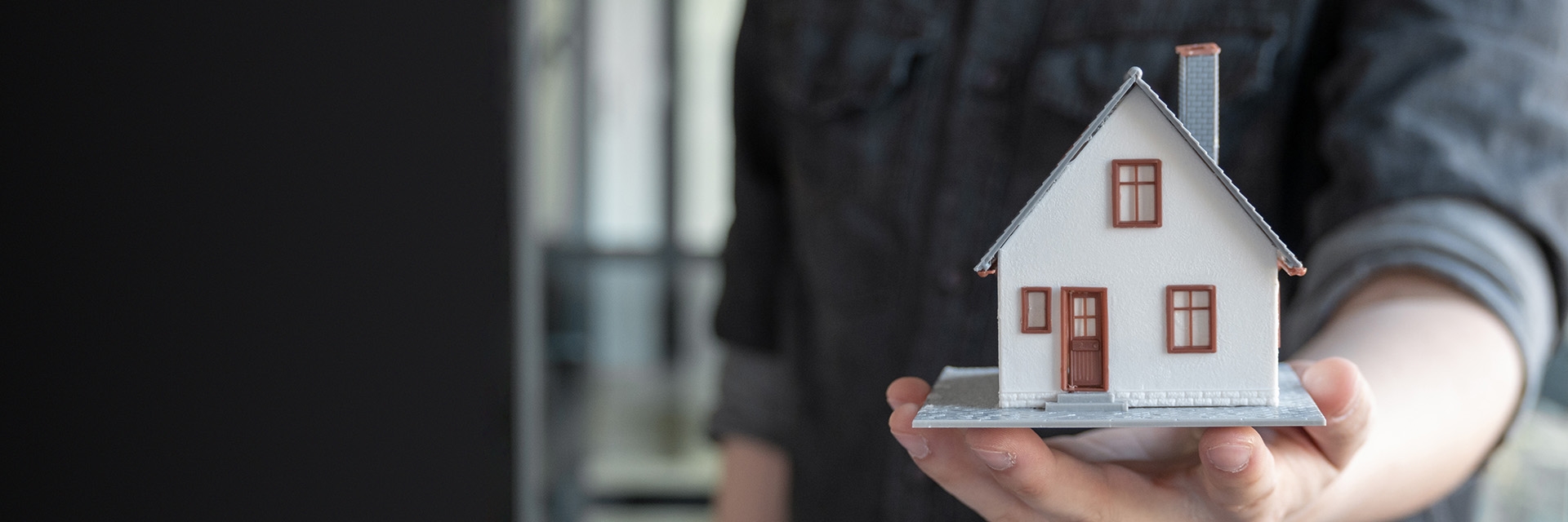 A man holding a miniature home