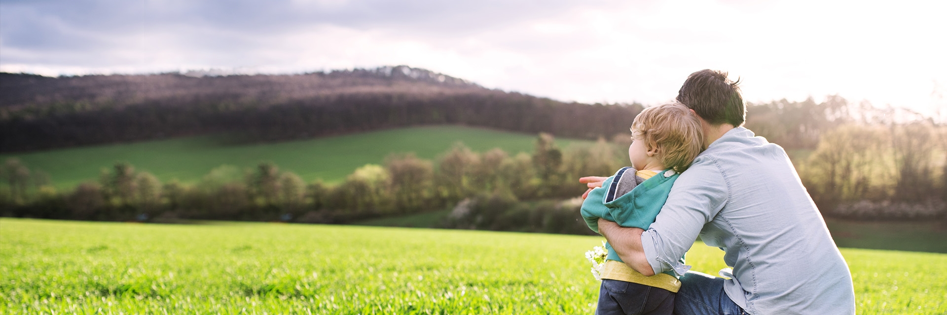 A man playing with his son in a field
